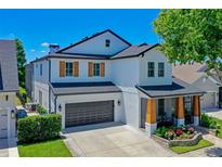 Beautiful two-story home with a dark gray garage door, wood-accented porch columns, and manicured landscaping at 722 Barefoot Bay Loop, Clermont, FL 34736