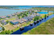 An aerial view of a waterfront community featuring homes with docks on a beautiful lake at 722 Barefoot Bay Loop, Clermont, FL 34736