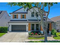 Charming two-story home with a well-manicured lawn, beautiful landscaping, and a two-car garage at 722 Barefoot Bay Loop, Groveland, FL 34736