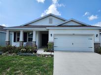 Charming single-story home with a well-manicured lawn and a two-car garage at 7974 Penrose Pl, Wildwood, FL 34785