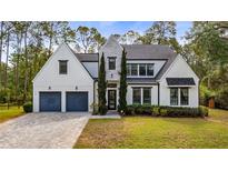 Stunning two-story home with a manicured lawn, gray driveway, and black trimmed windows and doors at 9134 Mossy Oak Ln, Clermont, FL 34711