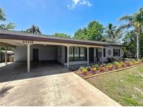 Charming home featuring a covered parking area and colorful landscaping at 11114 Lake Eustis Dr, Leesburg, FL 34788