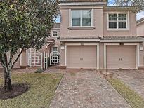 Charming townhome featuring brick driveway, attached two-car garage, and well-maintained landscaping at 1288 Grady Ln, Davenport, FL 33896