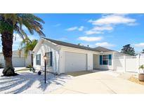 Charming single-story home featuring a well-manicured lawn and a two-car garage at 1404 Georgiana Ter, The Villages, FL 32162