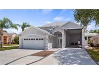 Beautiful home exterior featuring a two-car garage, attached carport, and manicured landscaping at 16608 W Citrus Pkwy, Clermont, FL 34714