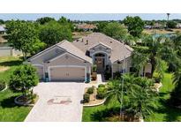 Charming single Gathering home with a two car garage, paver driveway, and manicured landscaping at 2237 Avon Loop, The Villages, FL 32162