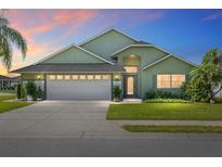 Charming single-story home with manicured lawn, mature landscaping, and a two-car garage at 2750 Coral Reef Way, Tavares, FL 32778