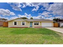 Charming single-story home with a well-manicured lawn, light-yellow brick, bright blue door and a two-car garage at 2833 Beal St, Deltona, FL 32738