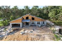 A new home construction featuring modern architectural elements in a wooded homesite at 30551 Saffron Ave, Eustis, FL 32736