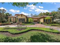 Beautiful front exterior of home with red tile roof, manicured landscaping and brick paved driveway at 32543 Hawks Lake Ln, Sorrento, FL 32776