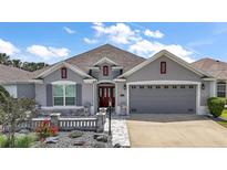 Charming one-story home featuring a gray exterior, well-manicured landscaping, and a two-car garage at 3537 Cluster Ct, The Villages, FL 32163