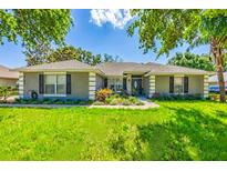 Charming single-story home with a well-manicured lawn and colorful landscaping around the entrance at 36700 Oconee Ave, Eustis, FL 32736