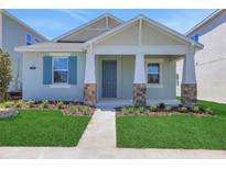 Charming single-story home showcasing manicured lawn and stone-accented porch columns at 5036 Blanket Flower St, Apopka, FL 32712