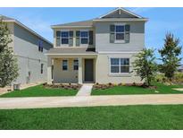 Charming two-story home with light exterior, manicured lawn, and dark shutters on a sunny day at 5105 Blanket Flower St, Apopka, FL 32712