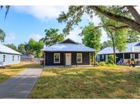 Charming single-story home with a black exterior, a metal roof, and a well-maintained lawn and walkway at 646 Nw 9Th Ave, Webster, FL 33597