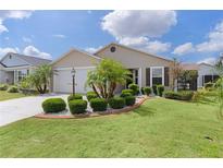 Charming home with lush green lawn, manicured landscaping, and palm trees for a tropical feel at 744 Shelton St, The Villages, FL 32163