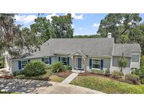 Charming single-story home with blue shutters, manicured lawn, and inviting walkway at 809 Northside Dr, Mount Dora, FL 32757