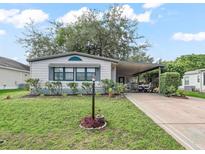 Charming single-story home with manicured lawn, covered parking, and cozy front garden at 941 Tarrson Blvd, Lady Lake, FL 32159