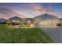 Charming single-story home featuring a well-manicured lawn and an attached two-car garage at 9461 Se 173Rd Ln, Summerfield, FL 34491