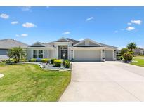 Charming single-story home featuring a well-manicured lawn and a three-car garage at 1182 Allaire Loop, The Villages, FL 32163