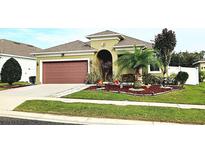 Charming single-story home with a well-manicured lawn, mature landscaping, and an attached two-car garage at 1231 Merion Dr, Mount Dora, FL 32757