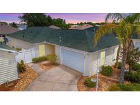 Well-maintained home featuring a two-car garage, mature landscaping, and a charming, quaint design at 1482 Azteca Loop, The Villages, FL 32162