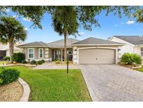 Beautiful home featuring a well-manicured lawn, paved driveway and two-car garage at 2015 Palo Alto Ave, The Villages, FL 32159
