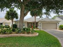 Charming one-story home featuring a well-manicured lawn, lovely garden, and attached two car garage at 2015 Palo Alto Ave, The Villages, FL 32159