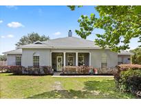 Charming single story home featuring a neutral exterior, arched windows and manicured landscaping on a lush lawn at 28924 Discovery Rd, Tavares, FL 32778