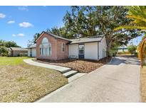 Charming home featuring a brick facade with a lovely arched window and cozy bench seating out front at 307 Water Shore Dr, Leesburg, FL 34748