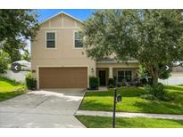 Two-story home featuring a two-car garage and a well-manicured lawn at 356 Giovani Blvd, Clermont, FL 34715