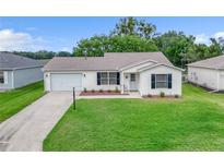 Charming single-story home with a well-maintained lawn and an attached garage, perfect for suburban living at 3590 Auburndale Ave, The Villages, FL 32162