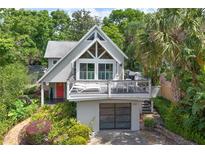 An appealing exterior featuring an elevated deck, modern garage door, and well-maintained landscaping at 421 W 10Th Ave, Mount Dora, FL 32757