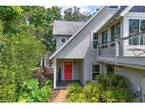 Charming home featuring a red front door and lush, well-maintained landscaping at 421 W 10Th Ave, Mount Dora, FL 32757