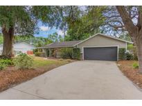 Charming single story home featuring an attached two car garage, and a spacious front yard with mature landscaping at 8410 Lake Bosse Dr, Orlando, FL 32810