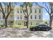 Beautiful exterior view of a multi-story condo building with mature landscaping, a black car, and balconies at 1021 Siena Park Blvd # 204, Kissimmee, FL 34747