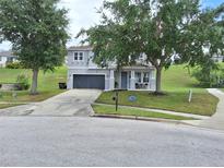 Charming two-story home with well-maintained landscaping and a gray two-car garage at 1033 N Jacks Lake Rd, Clermont, FL 34711