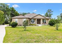 Charming single-story home with a well-maintained lawn and inviting front porch, perfect curb appeal at 10465 Se 41St Ter, Belleview, FL 34420