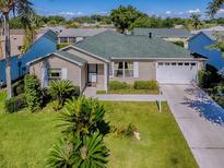 Charming single-story home featuring a well-manicured lawn, an attached garage, and mature landscaping at 1060 Davenport Dr, The Villages, FL 32162