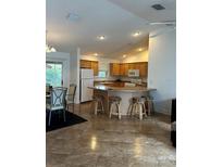 Open kitchen with a large island and seating, plus wood cabinets at 1060 Davenport Dr, The Villages, FL 32162