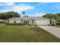 Charming single-story home with a well-manicured lawn, mature trees, and an attached one-car garage at 111 Ridgeview Cir, Eustis, FL 32726
