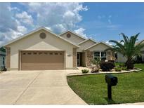 Charming single-story home featuring a manicured lawn, well-maintained landscaping, and a two-car garage at 11277 Se 170Th Ln, Summerfield, FL 34491