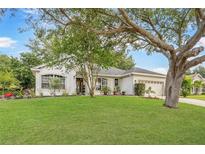 Beautiful single-story home with a lush lawn and mature trees offering great curb appeal at 13332 Via Roma Cir, Clermont, FL 34711