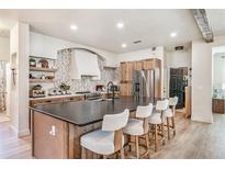 Spacious kitchen featuring a large island with seating, stainless steel appliances, and custom backsplash at 13332 Via Roma Cir, Clermont, FL 34711