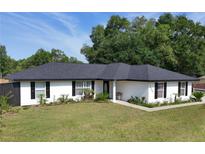 Charming single-story home featuring a well-manicured lawn and freshly painted exterior at 14350 Se 36Th Ave, Summerfield, FL 34491