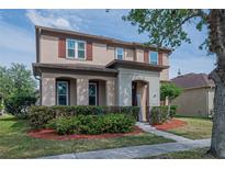 Charming two-story home featuring well-manicured landscaping and an inviting entrance at 14832 Royal Poinciana Dr, Orlando, FL 32828
