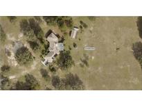 Aerial view of a home with pool and sun panels, situated on a large property with mature trees at 23130 Brouwertown Rd, Howey In The Hills, FL 34737