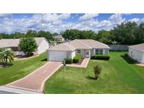 Charming single-story home featuring a well-manicured lawn and attached one car garage at 2369 Five Forks Trl, The Villages, FL 32162