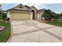 Beautiful home featuring a decorative driveway, a two-car garage, and a well-maintained lawn at 2918 Canyon Ave, The Villages, FL 32163