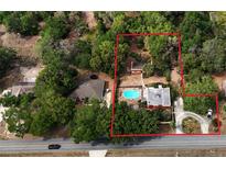 Expansive aerial view showcasing the property's layout, pool, mature trees, and surrounding landscape at 308 Sunnyside Dr, Leesburg, FL 34748